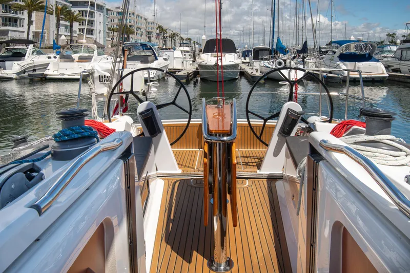 Anthem Yacht Photos Pics 2022 Dehler 34 sailboat cockpit with dual steering wheels in a marina setting.