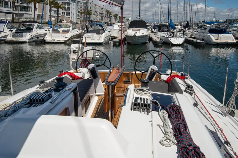 Anthem Yacht Photos Pics 2022 Dehler 34 sailboat cockpit view in a marina with multiple yachts.
