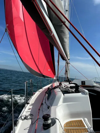 Anthem Yacht Photos Pics 2022 Dehler 34 sailboat with vibrant red sail on open water.