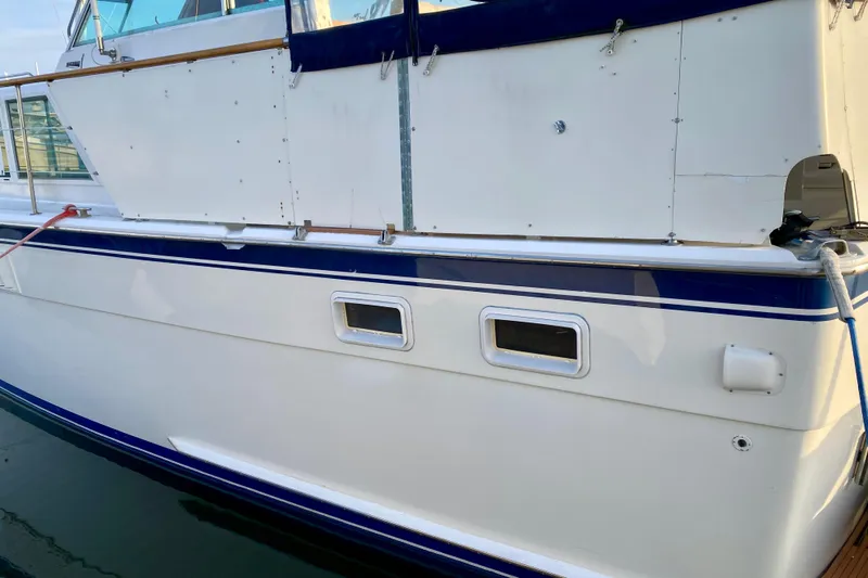 Lazy Livin' Yacht Photos Pics 1971 Hatteras 43 Double Cabin yacht side view with blue trim and windows.