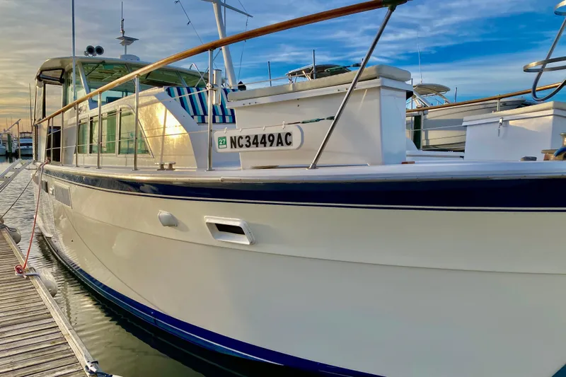 Lazy Livin' Yacht Photos Pics 1971 Hatteras 43 Double Cabin yacht docked at marina, sunset reflection on water.