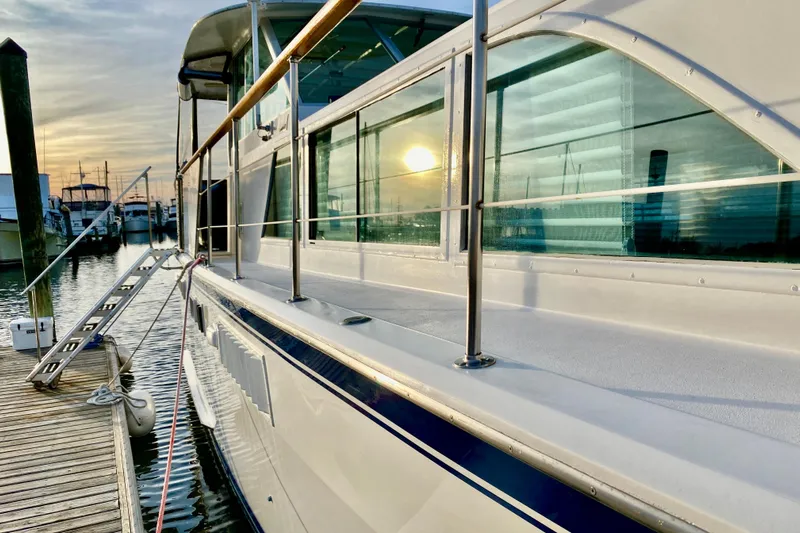 Lazy Livin' Yacht Photos Pics 1971 Hatteras 43 Double Cabin yacht docked at sunset, reflecting on water.