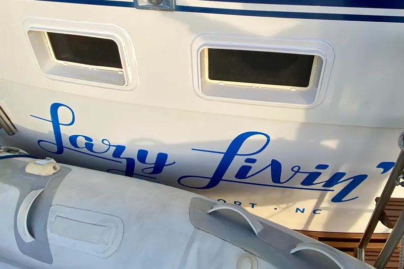 Lazy Livin' Yacht Photos Pics 1971 Hatteras 43 Double Cabin boat with "Lazy Livin'" name, docked with inflatable dinghy.