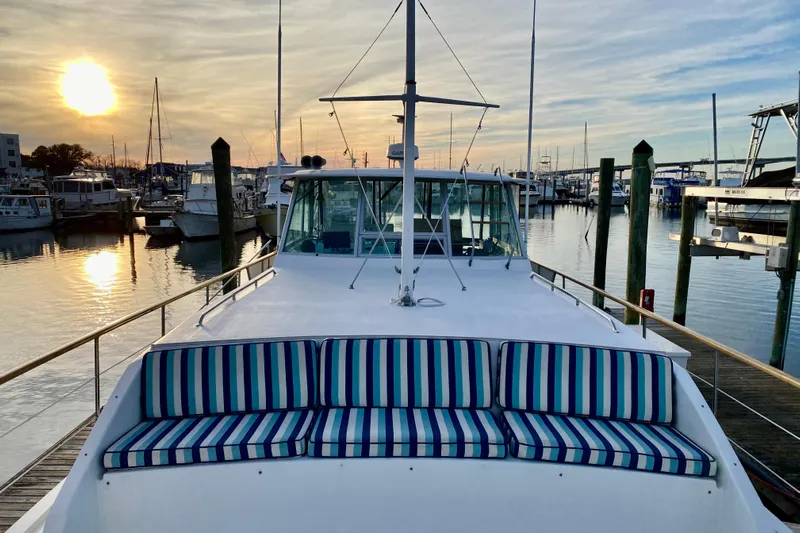 Lazy Livin' Yacht Photos Pics 1971 Hatteras 43 Double Cabin yacht at sunset in marina, striped seating.