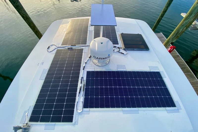 Lazy Livin' Yacht Photos Pics Rooftop solar panels on a 1971 Hatteras 43 Double Cabin boat, docked by the water.