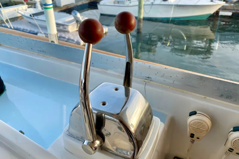 Lazy Livin' Yacht Photos Pics Throttle controls on a 1971 Hatteras 43 Double Cabin boat, docked by the water.