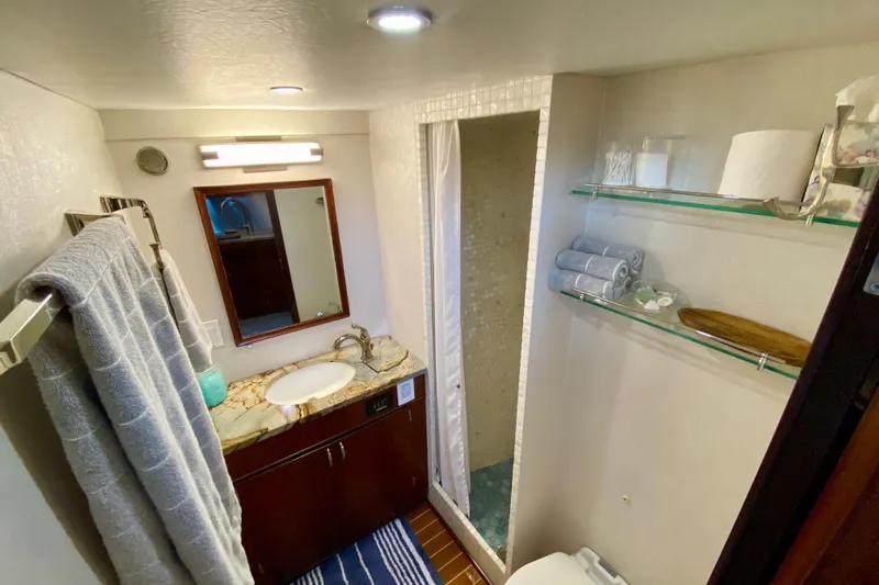 Lazy Livin' Yacht Photos Pics Bathroom interior of 1971 Hatteras 43 Double Cabin yacht, featuring sink, mirror, and shower.