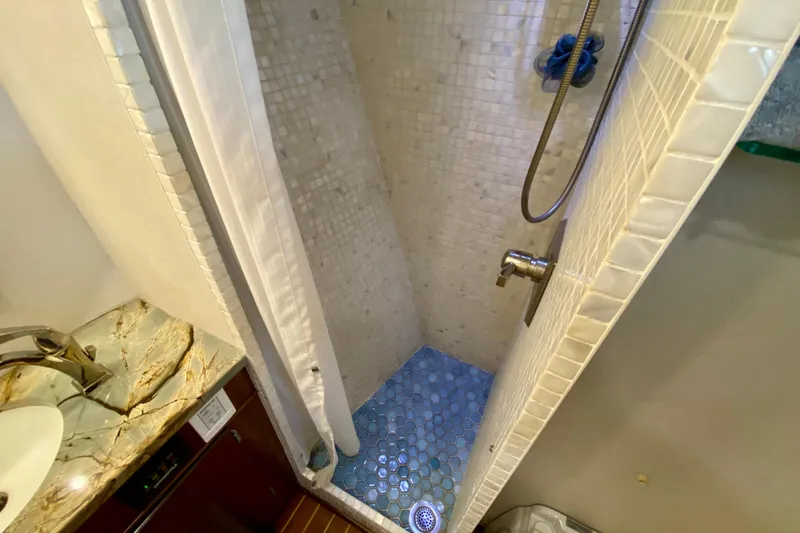 Lazy Livin' Yacht Photos Pics Shower area in 1971 Hatteras 43 Double Cabin yacht with mosaic tiles and marble sink.