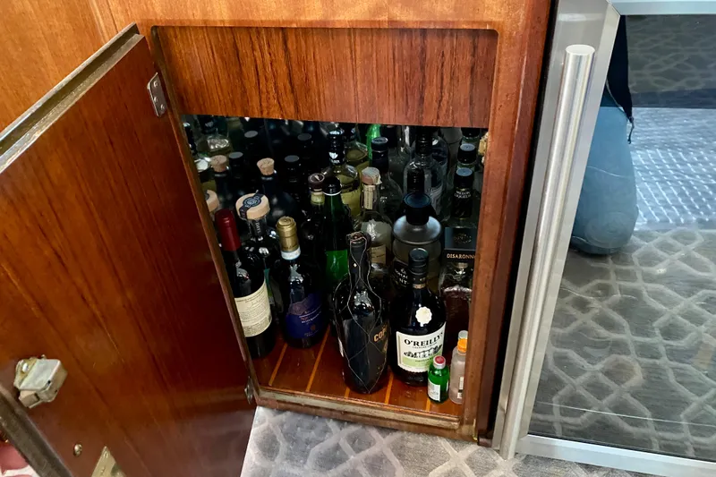 Lazy Livin' Yacht Photos Pics 1971 Hatteras 43 Double Cabin liquor cabinet with assorted bottles.