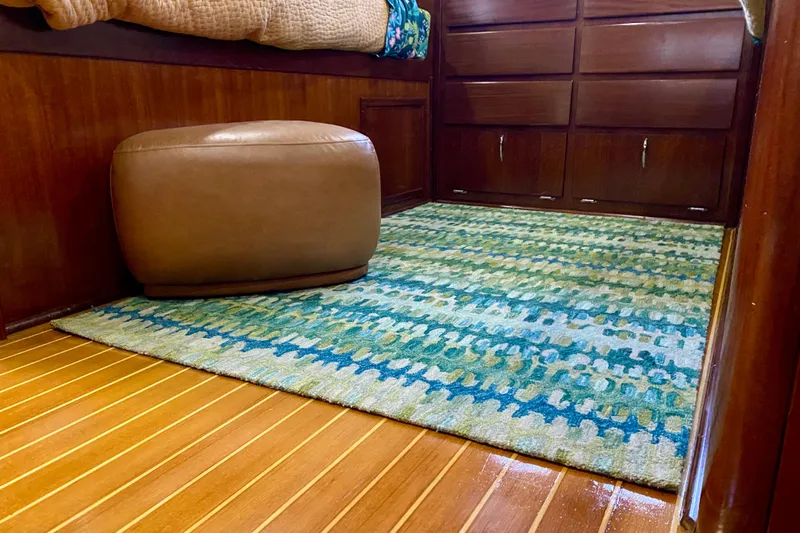 Lazy Livin' Yacht Photos Pics Interior of 1971 Hatteras 43 Double Cabin with colorful rug and leather ottoman.