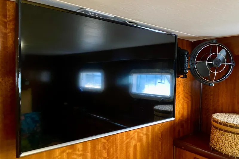 Lazy Livin' Yacht Photos Pics Flat-screen TV and fan inside 1971 Hatteras 43 Double Cabin yacht interior.