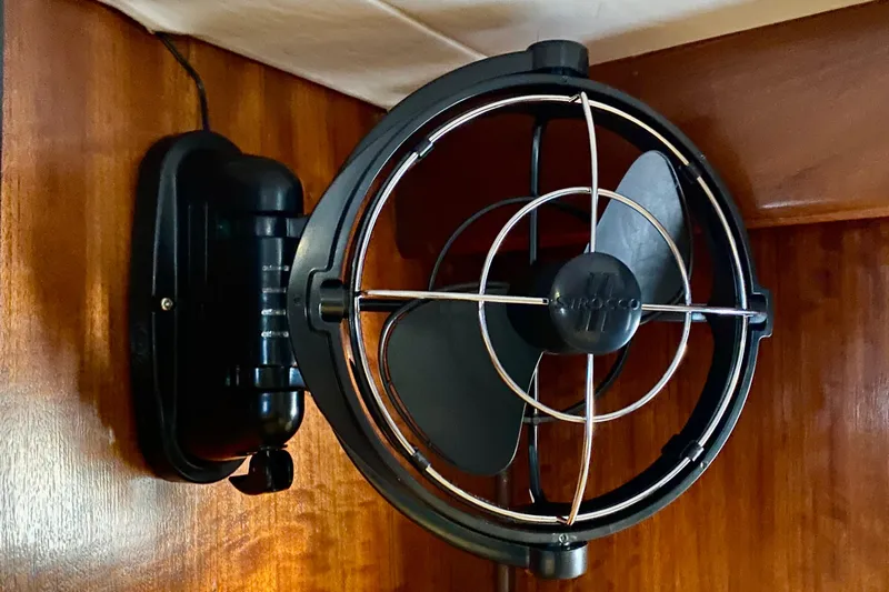Lazy Livin' Yacht Photos Pics Wall-mounted fan inside 1971 Hatteras 43 Double Cabin, featuring wooden paneling.