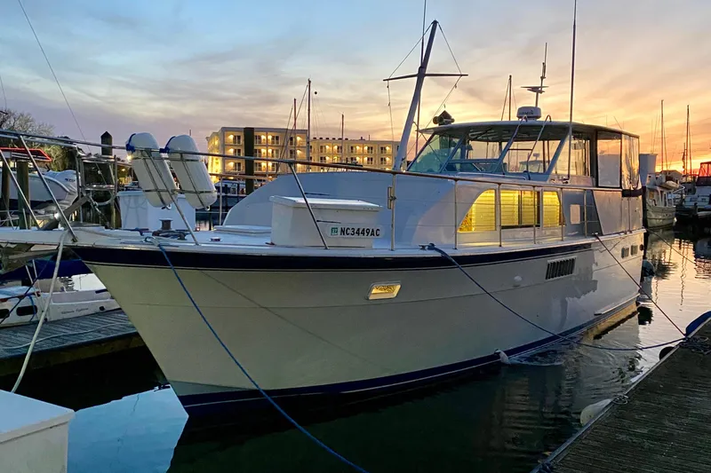 Lazy Livin' Yacht Photos Pics 1971 Hatteras 43 Double Cabin yacht docked at sunset, illuminated windows.