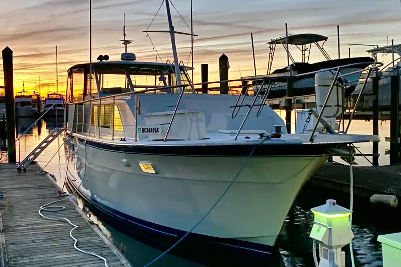 Lazy Livin' Yacht Photos Pics 1971 Hatteras 43 Double Cabin yacht docked at sunset, marina background.