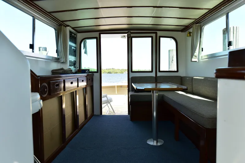 About Time Yacht Photos Pics Interior of 1998 Duffy 35 Downeast Cruiser with seating and table, overlooking water.