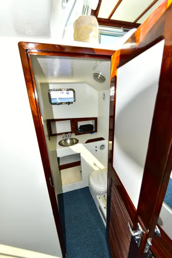 About Time Yacht Photos Pics 1998 Duffy 35 Downeast Cruiser bathroom with wooden door, sink, and toilet.