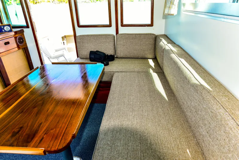 About Time Yacht Photos Pics Interior of 1998 Duffy 35 Downeast Cruiser with cushioned seating and wooden table.