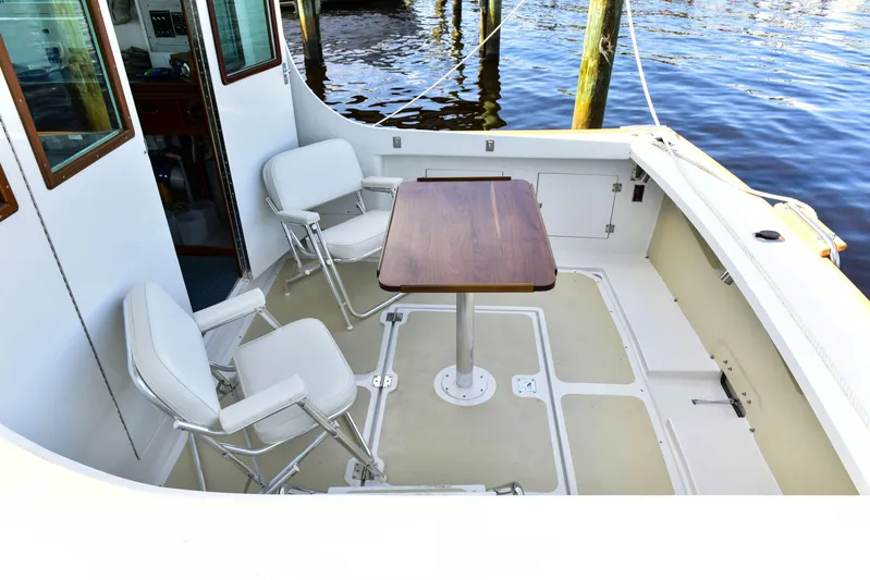 About Time Yacht Photos Pics 1998 Duffy 35 Downeast Cruiser deck with chairs and table by the water.