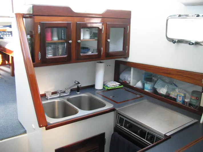 About Time Yacht Photos Pics Compact kitchen in 1998 Duffy 35 Downeast Cruiser with dual sinks and wooden cabinets.