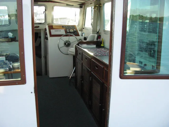 About Time Yacht Photos Pics Interior of a 1998 Duffy 35 Downeast Cruiser with steering wheel and wooden cabinetry.