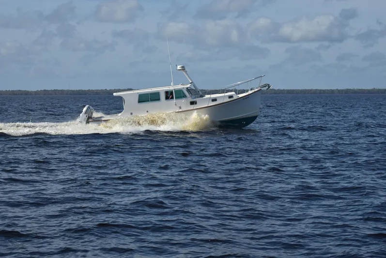About Time Yacht Photos Pics 1998 Duffy 35 Downeast Cruiser navigating open waters under a cloudy sky.