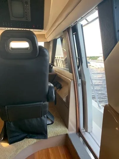  Yacht Photos Pics Interior view of 1999 Carver 450 Voyager yacht, featuring helm seat and open side window.