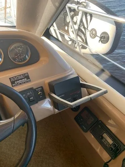  Yacht Photos Pics 1999 Carver 450 Voyager helm with gauges and controls, featuring a side mirror view.