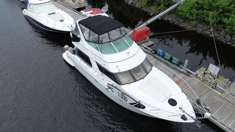  Yacht Photos Pics Aerial view of a 1999 Carver 450 Voyager yacht docked by a wooden pier.