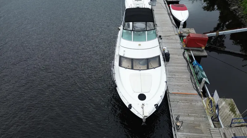  Yacht Photos Pics 1999 Carver 450 Voyager yacht docked at a wooden pier, aerial view.