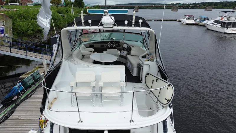  Yacht Photos Pics 1999 Carver 450 Voyager yacht docked at a marina, featuring spacious deck and seating area.