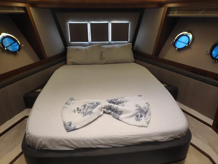  Yacht Photos Pics Luxurious bedroom in 2013 Monte Carlo Yachts MCY 65 with elegant bedding and porthole windows.