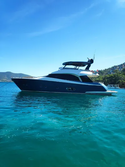  Yacht Photos Pics Luxurious 2013 Monte Carlo Yachts MCY 65 cruising on clear blue waters.