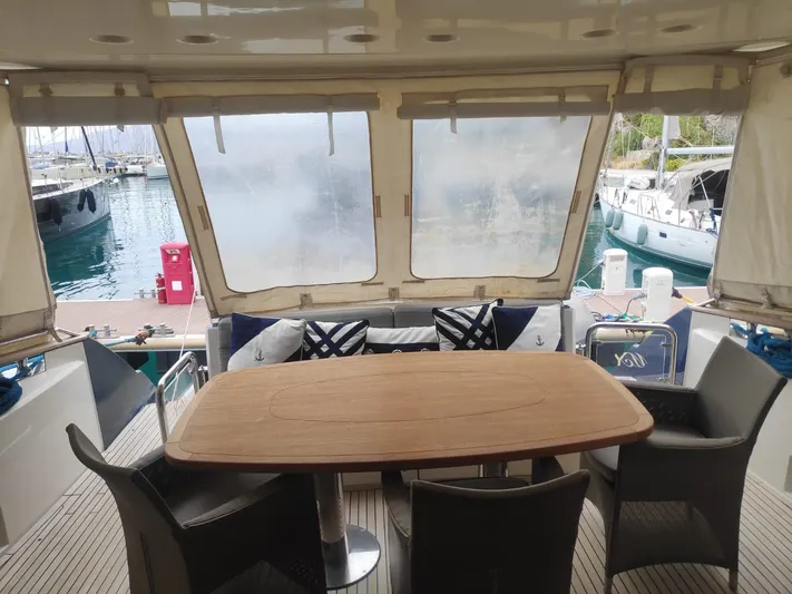  Yacht Photos Pics Luxurious 2013 Monte Carlo Yachts MCY 65 aft deck with dining table and marina view.