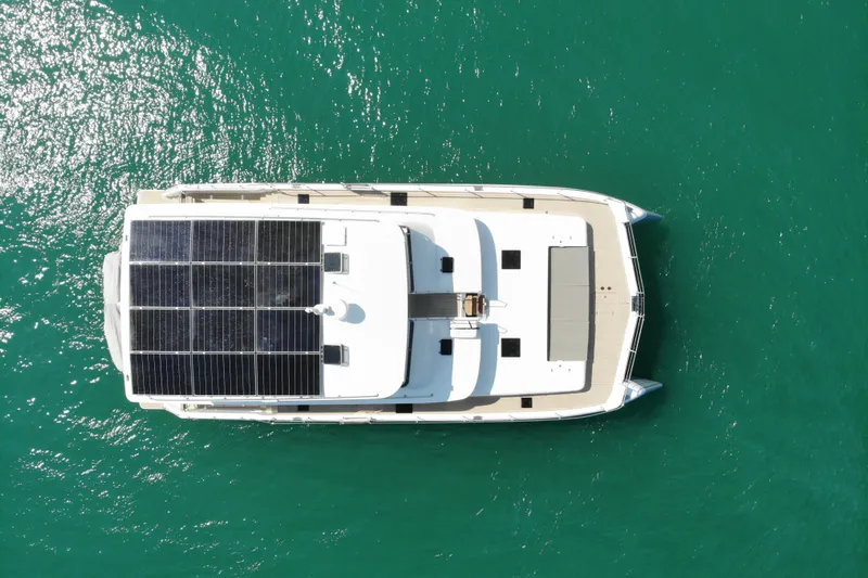 Innforapenny III Yacht Photos Pics Overhead view of 2020 PowerPlay Catamarans Longreach 1900 Expedition with solar panels on turquoise water.