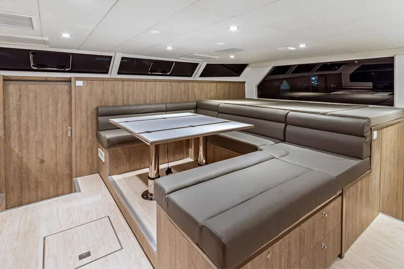 Innforapenny III Yacht Photos Pics Luxurious interior of 2020 PowerPlay Catamarans Longreach 1900 Expedition with modern seating and table.