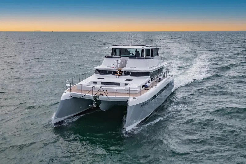Innforapenny III Yacht Photos Pics 2020 PowerPlay Catamarans Longreach 1900 Expedition cruising on open sea at sunset.