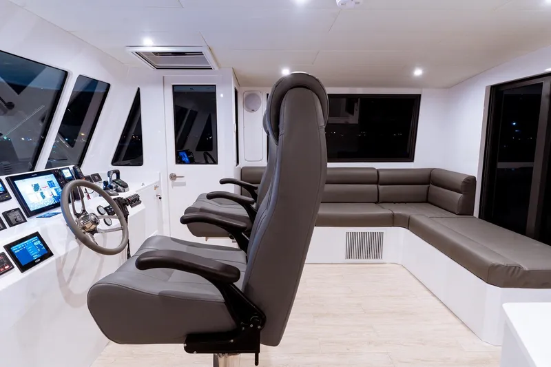 Innforapenny III Yacht Photos Pics Modern helm station of 2020 PowerPlay Catamarans Longreach 1900 Expedition with sleek seating and controls.