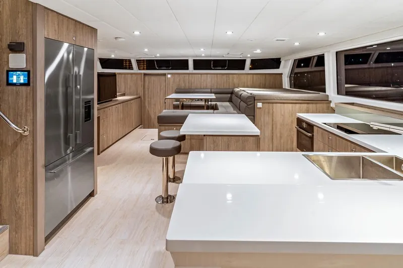 Innforapenny III Yacht Photos Pics Luxurious interior of 2020 PowerPlay Catamarans Longreach 1900 Expedition with modern kitchen and seating area.