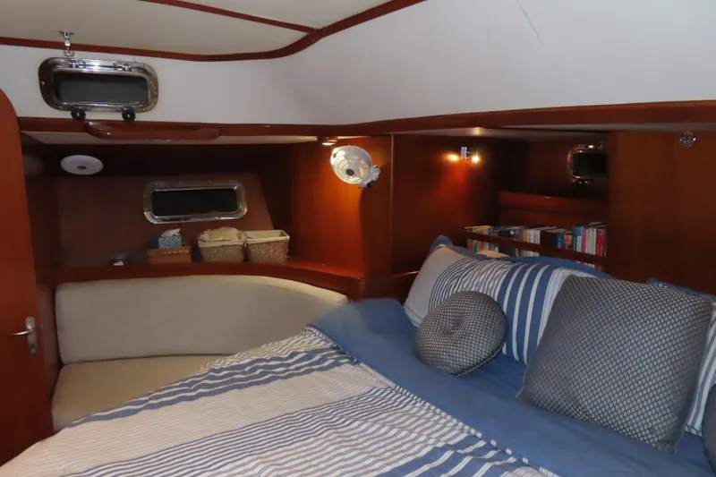 Sea Pearl Yacht Photos Pics Cozy cabin interior of 1998 Hylas 54' yacht with striped bedding and wooden accents.