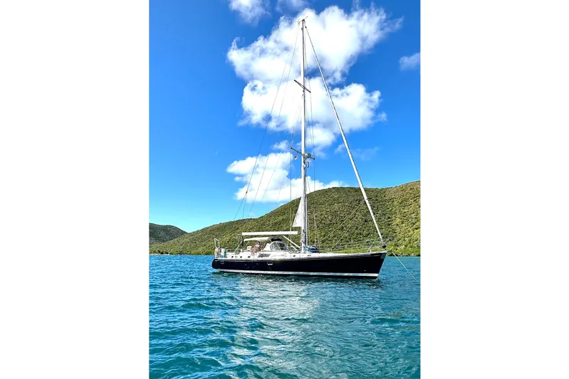 Sea Pearl Yacht Photos Pics Sailing yacht Hylas 54' (1998) on blue water with green hills and clear sky.