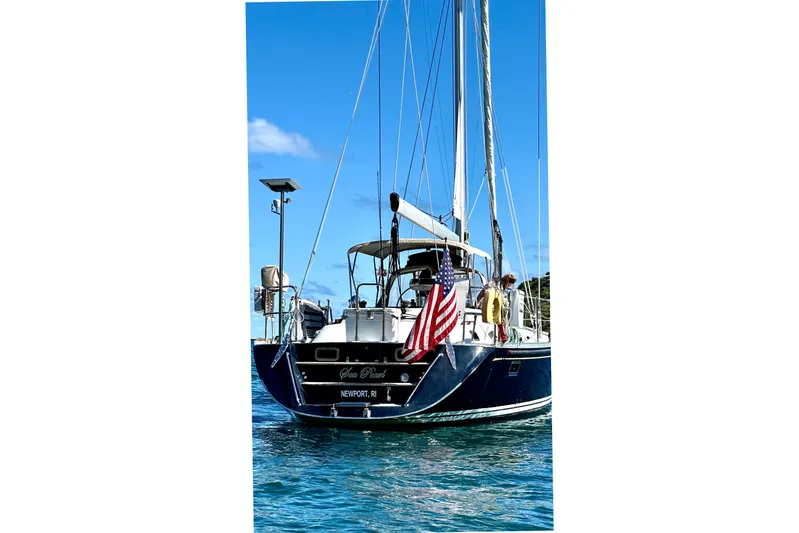 Sea Pearl Yacht Photos Pics Sailing yacht Hylas 54', 1998 model, with American flag, on blue water.