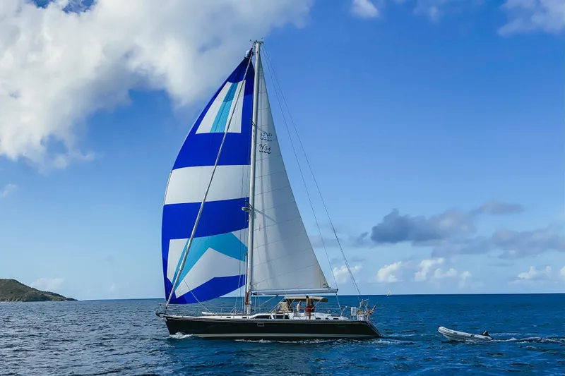 Sea Pearl Yacht Photos Pics Sailing yacht Hylas 54' (1998) with blue and white spinnaker on open sea.