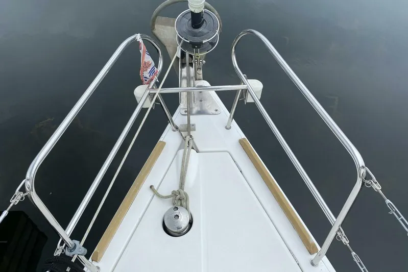 J'ouvert Yacht Photos Pics Bow of 2009 Beneteau 43 sailboat with stainless steel railings and calm water reflection.