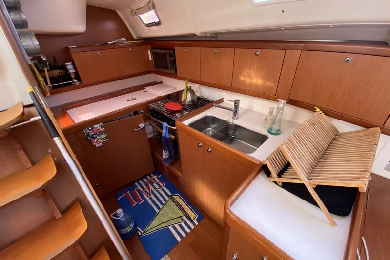 J'ouvert Yacht Photos Pics Interior of 2009 Beneteau 43 sailboat kitchen with wooden cabinets and modern appliances.