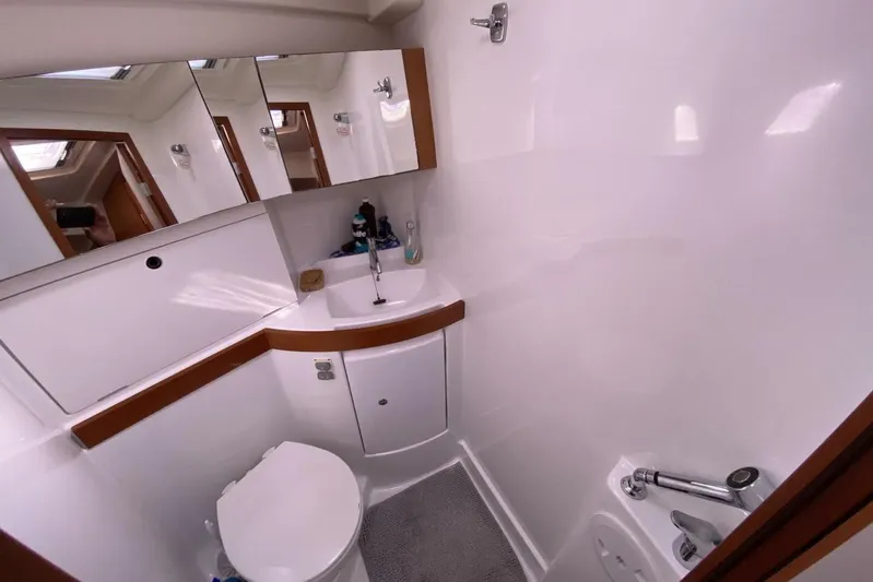 J'ouvert Yacht Photos Pics Bathroom interior of 2009 Beneteau 43 yacht, featuring sink, toilet, and mirrored cabinets.
