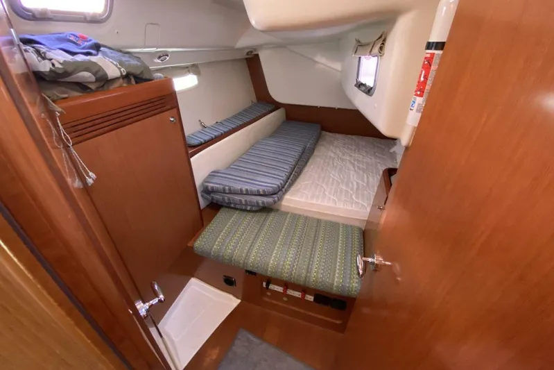 J'ouvert Yacht Photos Pics Interior cabin of 2009 Beneteau 43 yacht with wooden finish and cozy bedding.