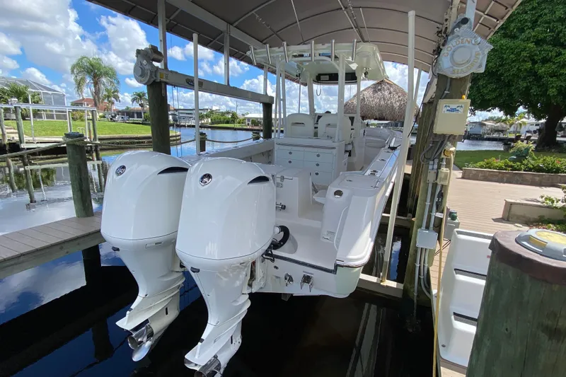 Pretty Fine Yacht Photos Pics 2015 Edgewater 320CC boat with dual engines docked under a canopy.