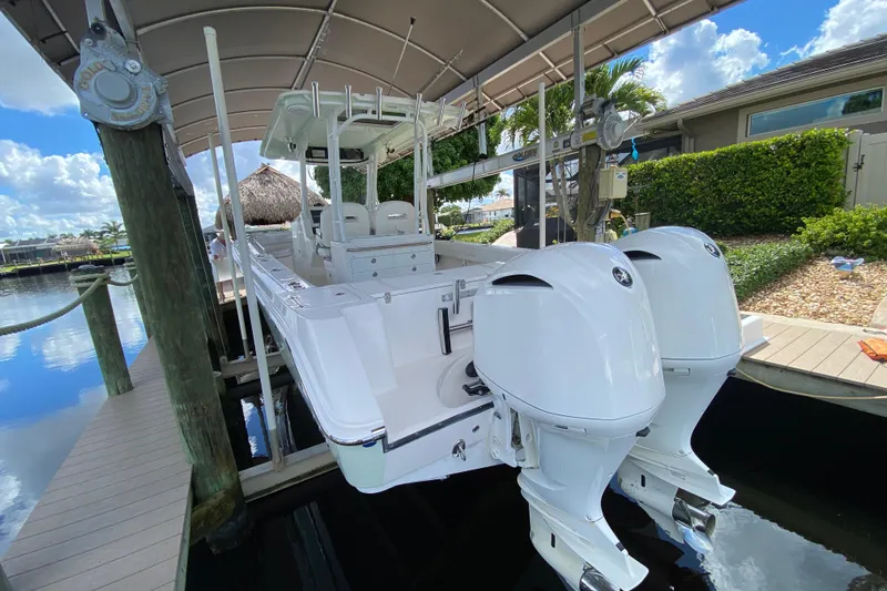 Pretty Fine Yacht Photos Pics 2015 Edgewater 320CC boat with dual engines docked under a canopy.