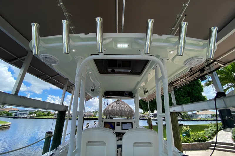 Pretty Fine Yacht Photos Pics 2015 Edgewater 320CC boat interior with rod holders, docked by a scenic waterfront.