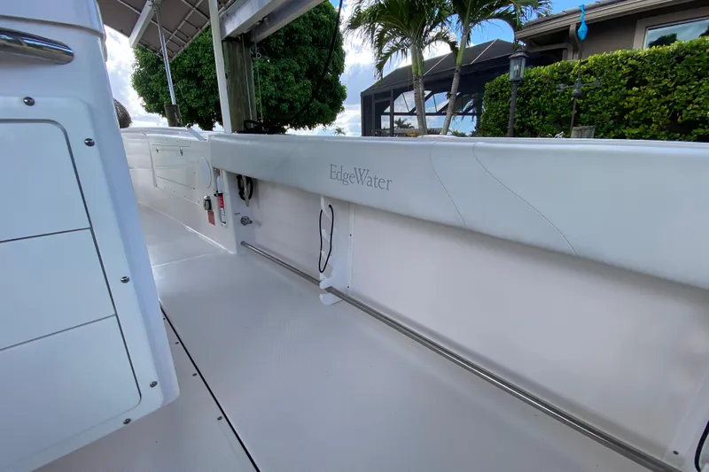 Pretty Fine Yacht Photos Pics 2015 Edgewater 320CC boat interior with white seating and lush greenery background.